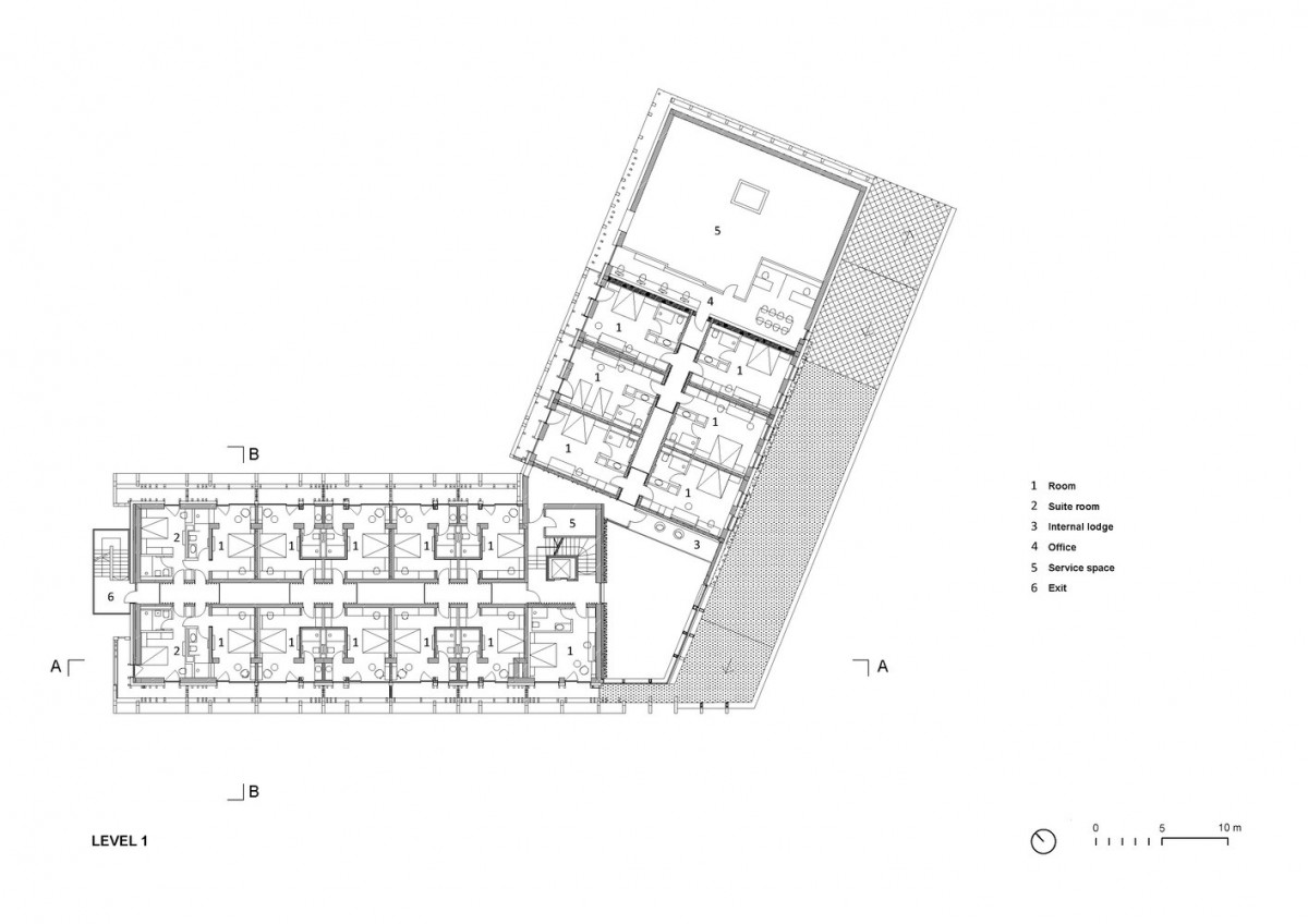 hotel bohinj Črno-beli arhitekturni tloris 1. nadstropja stavbe, ki prikazuje oštevilčene sobe, pisarne, servisne prostore, hodnike, izhode in ključ območij; vključuje severno puščico in merilo v metrih.