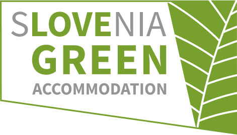 hotel bohinj Logotip z napisom "Slovenia Green Accommodation" v sivi in zeleni barvi ob stiliziranem zelenem listu s krepkimi žilami na desni strani.
